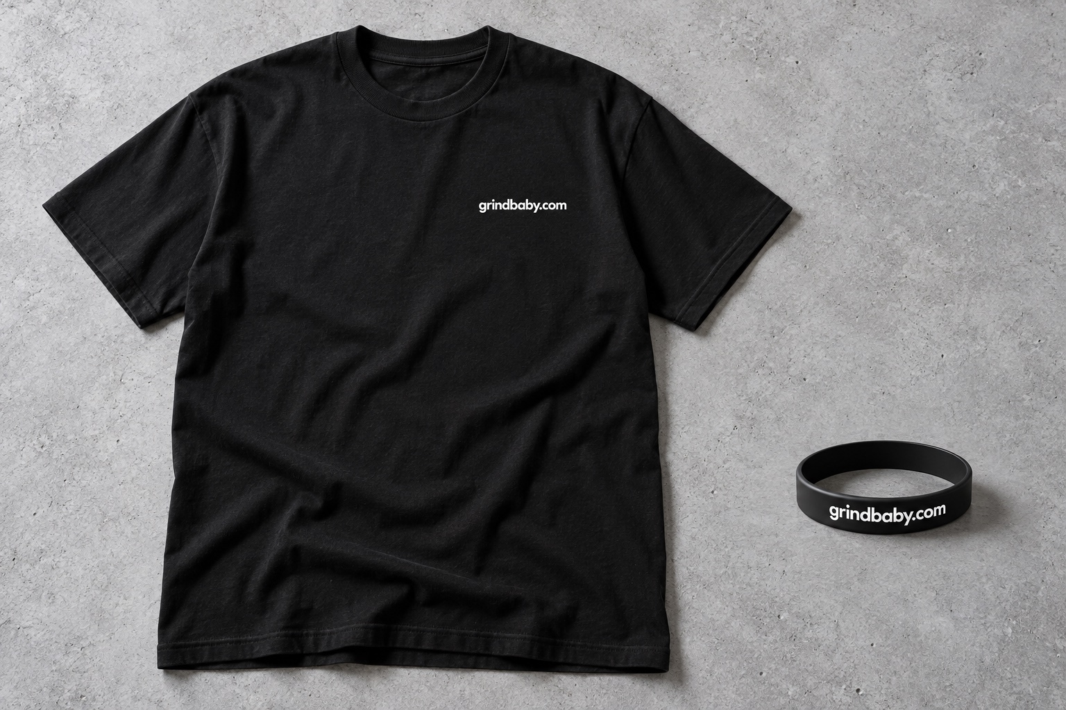 Design visualization of a black T-shirt and black wristband, both marked grindbaby.com in lowercase white lettering